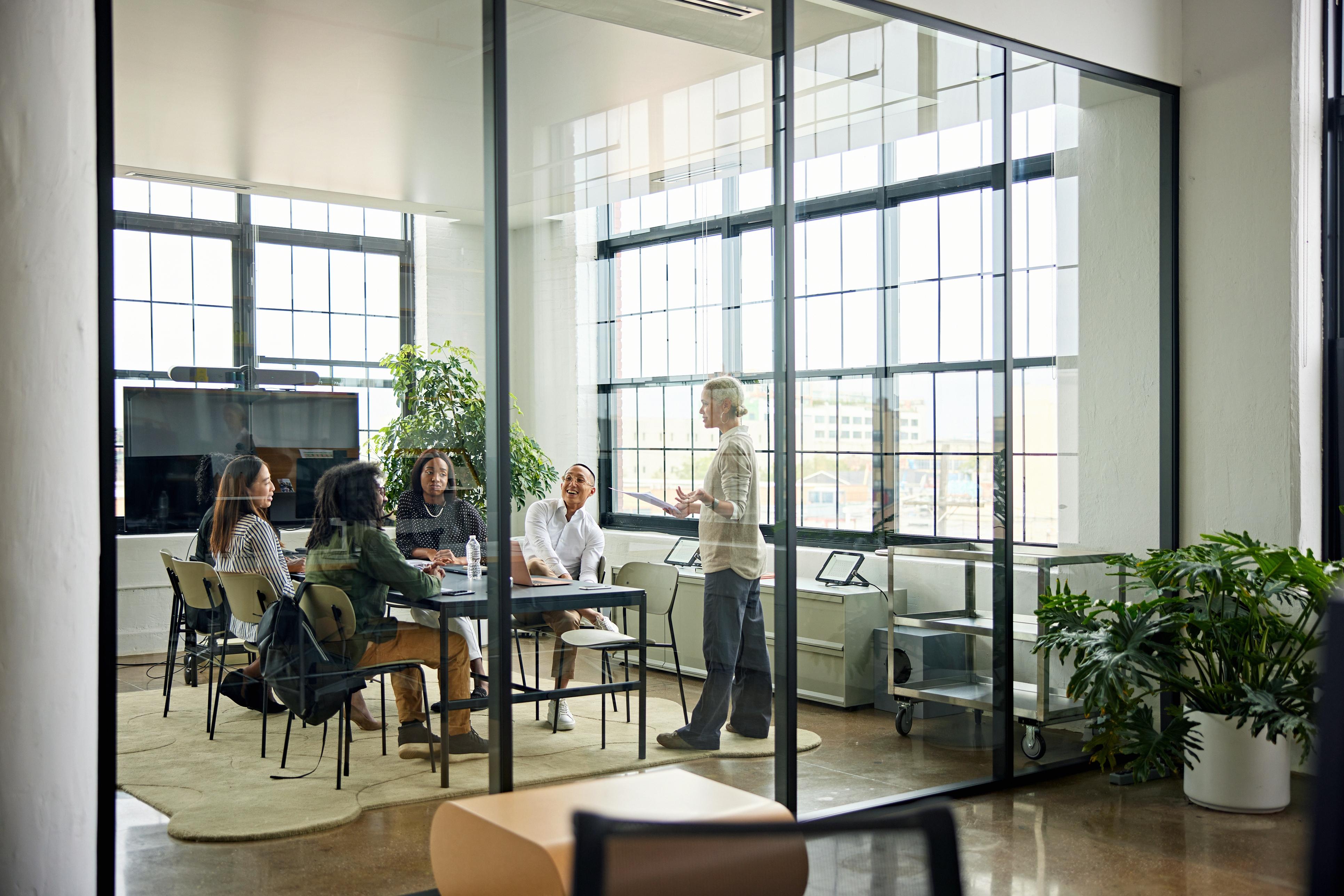 Smiling colleagues meeting in modern conference room