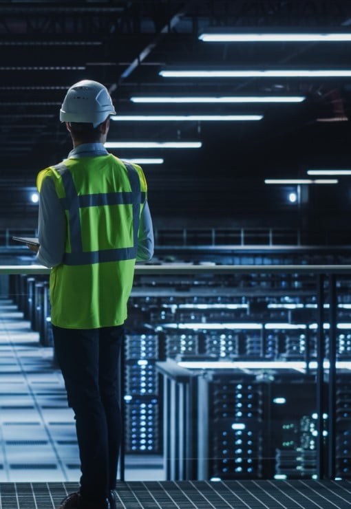 Person wearing a high vis jacket looking over a data centre