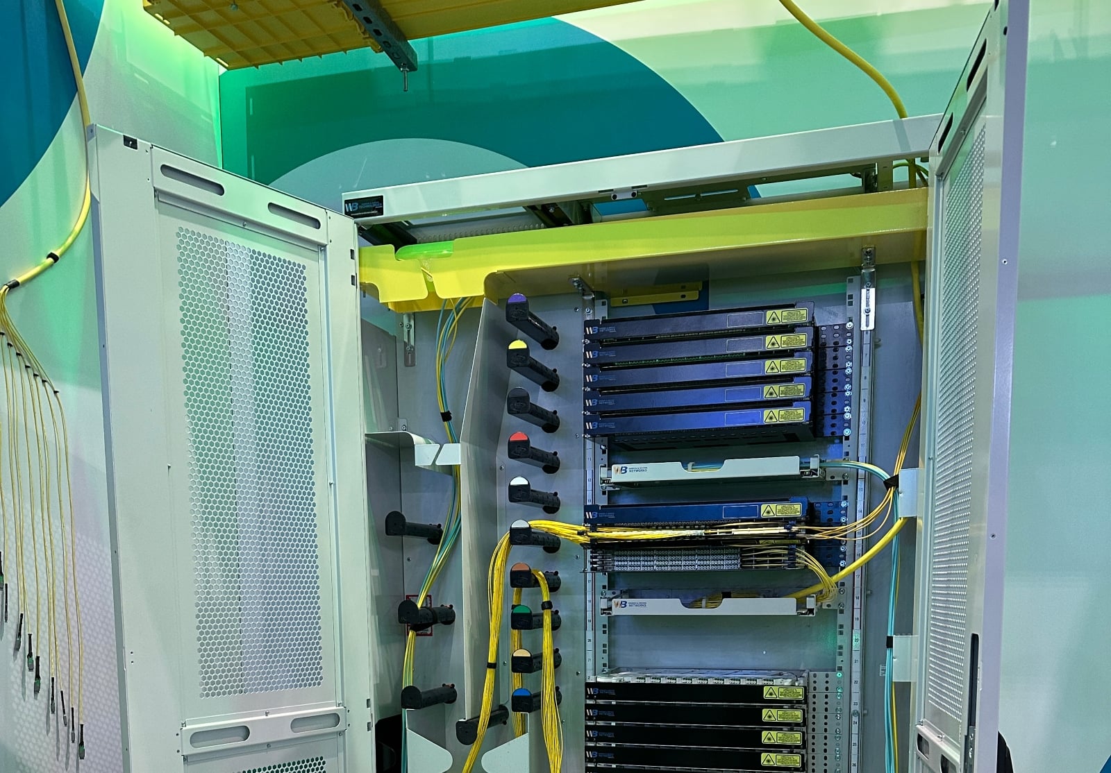 An image of tall cabinet with racks that hold fibre cables