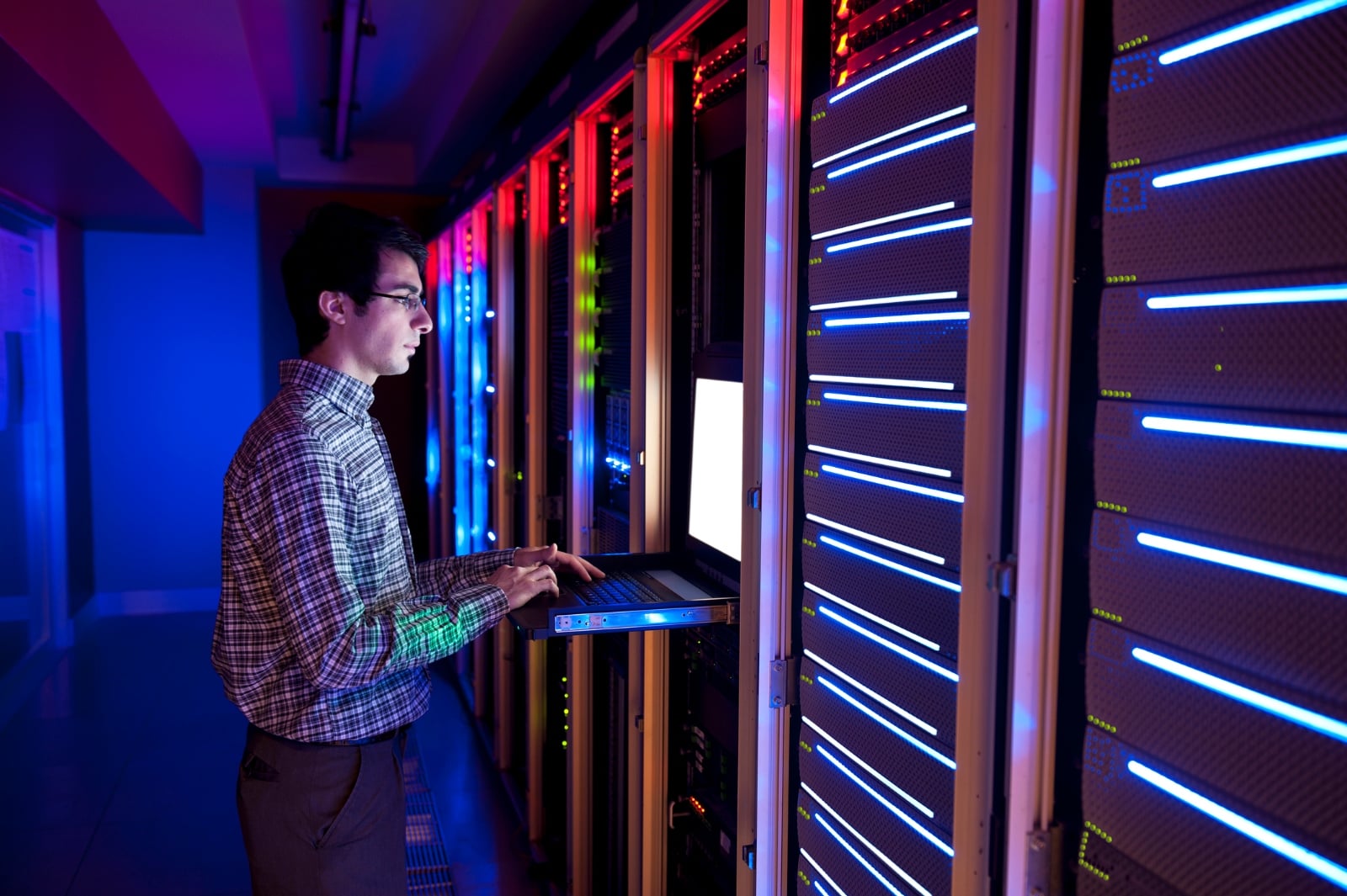 image of IT specialist looking at his laptop in a data centre