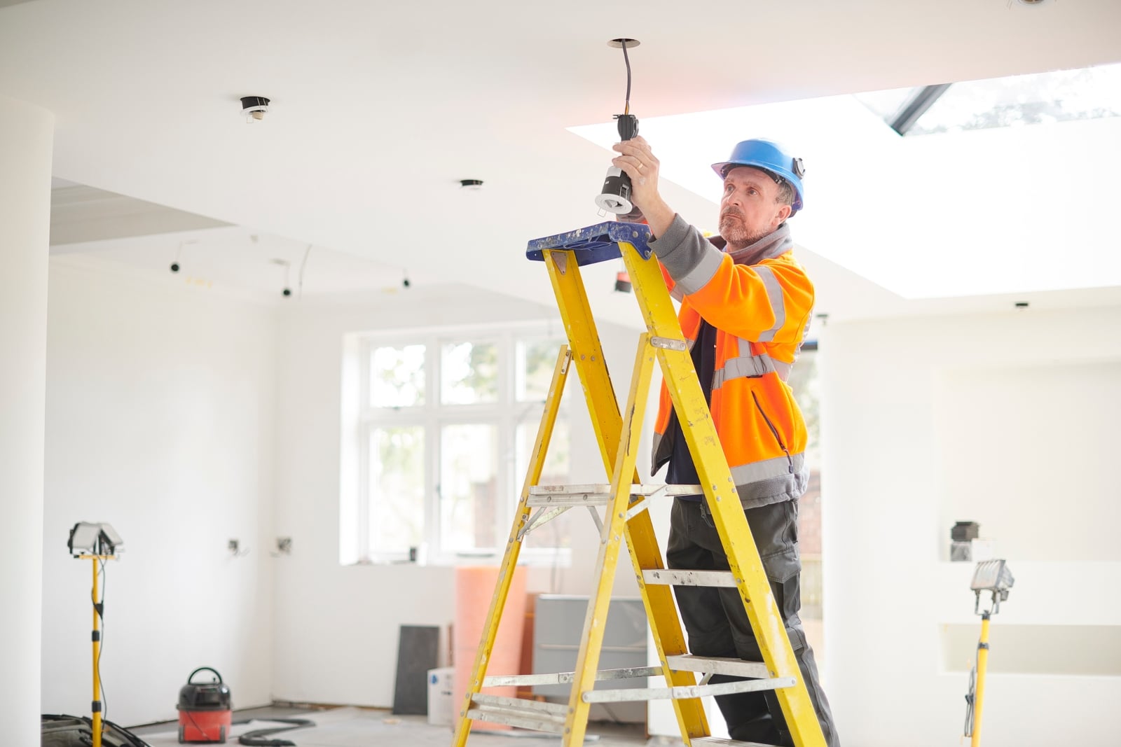 an image of an electrician installing a light fitting