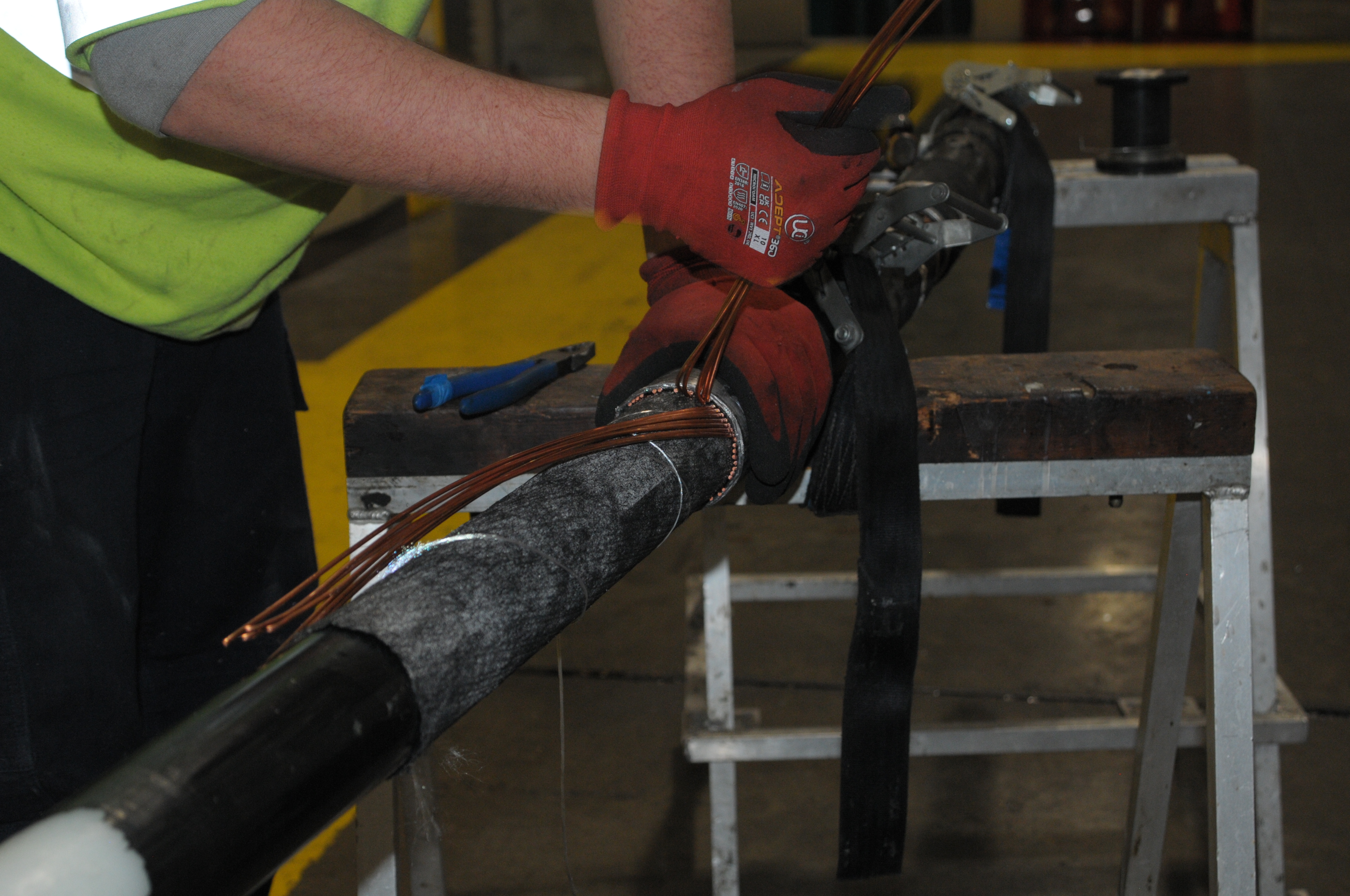 Person in a high vis jacket working on a large cable