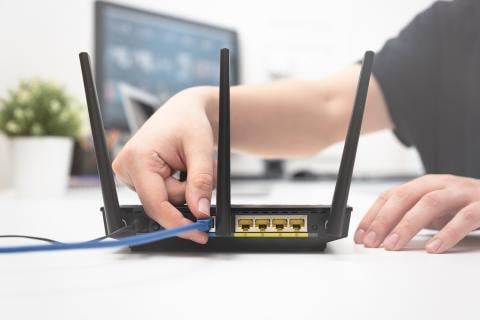 An image of someone inserting a cable into a WiFi box.